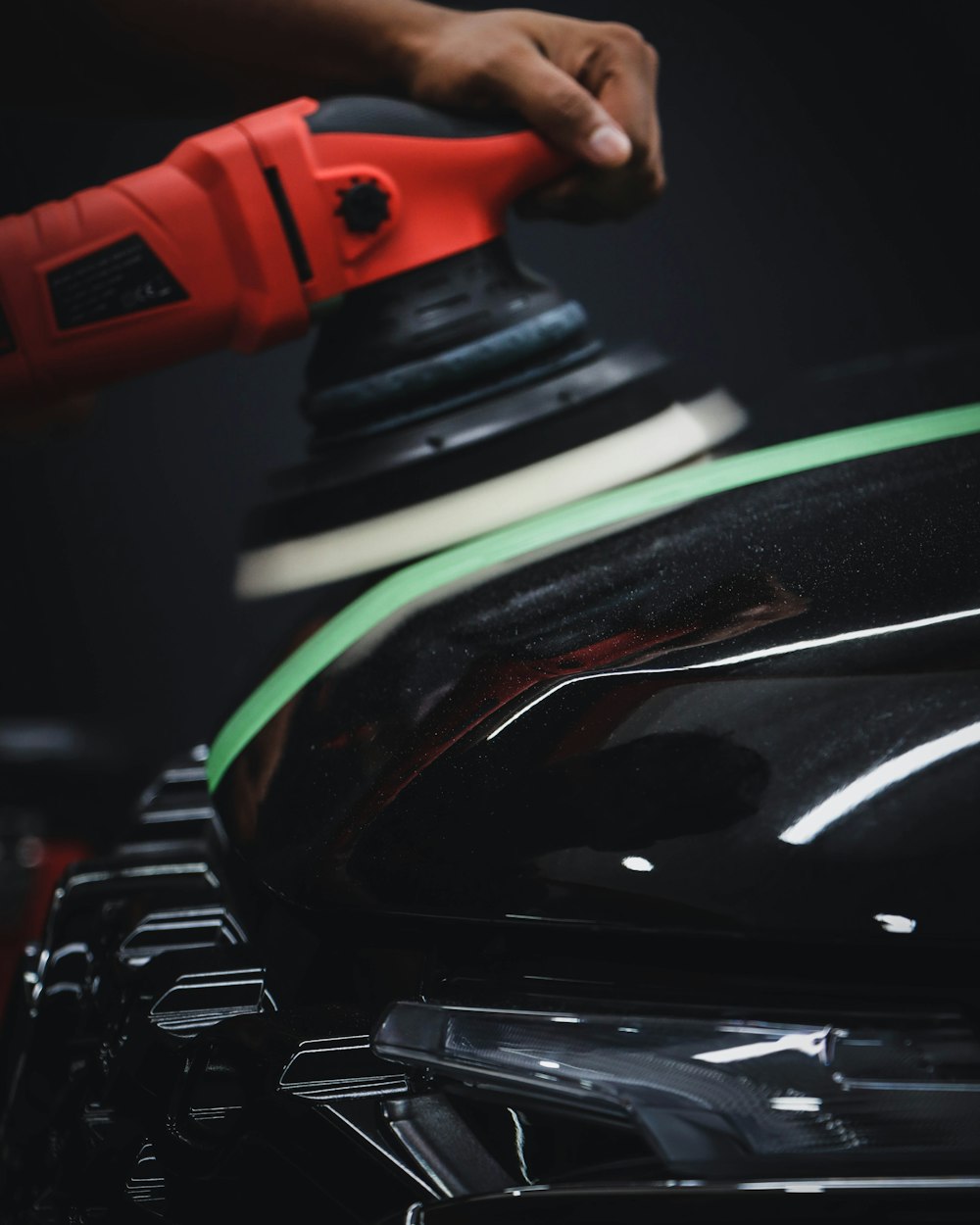 A polishing pad refining a glossy automotive finish
