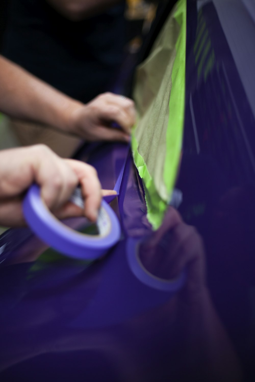 Hands preparing and correcting an automotive panel before painting